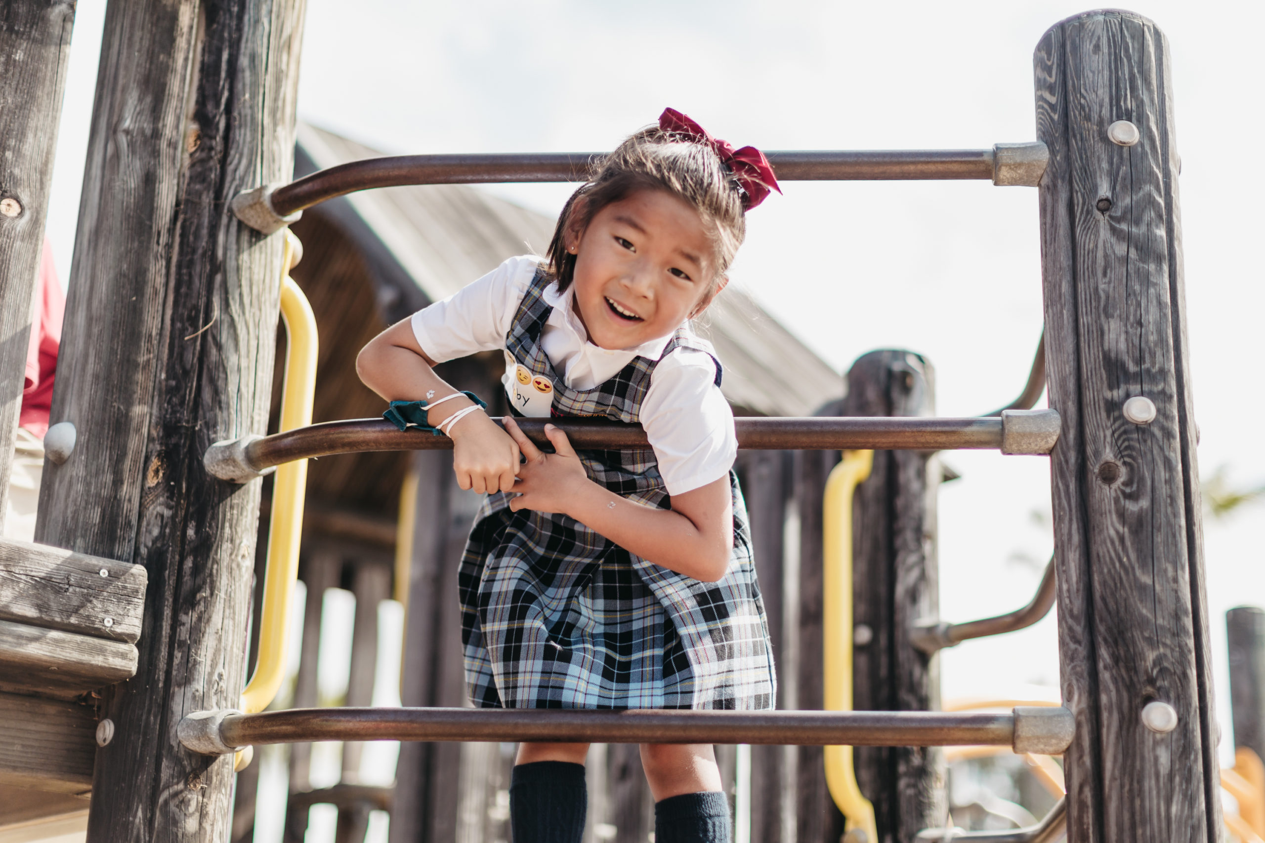 SFC kindergartener smiles for the camera while playing on the playground.